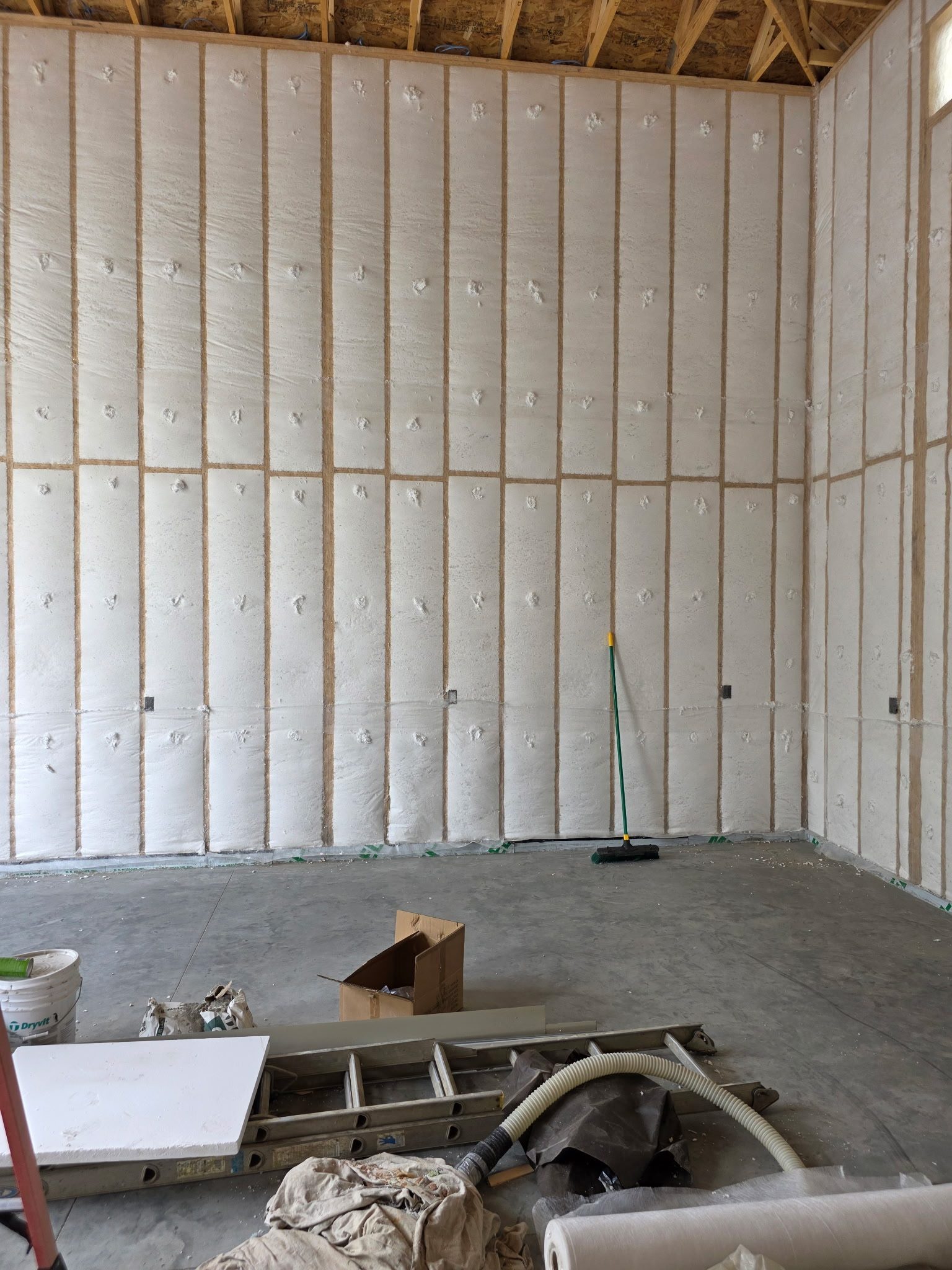 Closed-cell spray foam insulation freshly applied to stud walls in a Sioux Falls, SD new-construction building